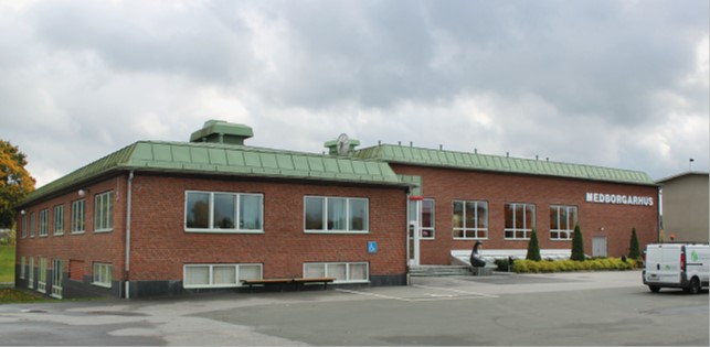 Låg tegelbyggnad med grönt tak och texten medborgarhus på fasaden