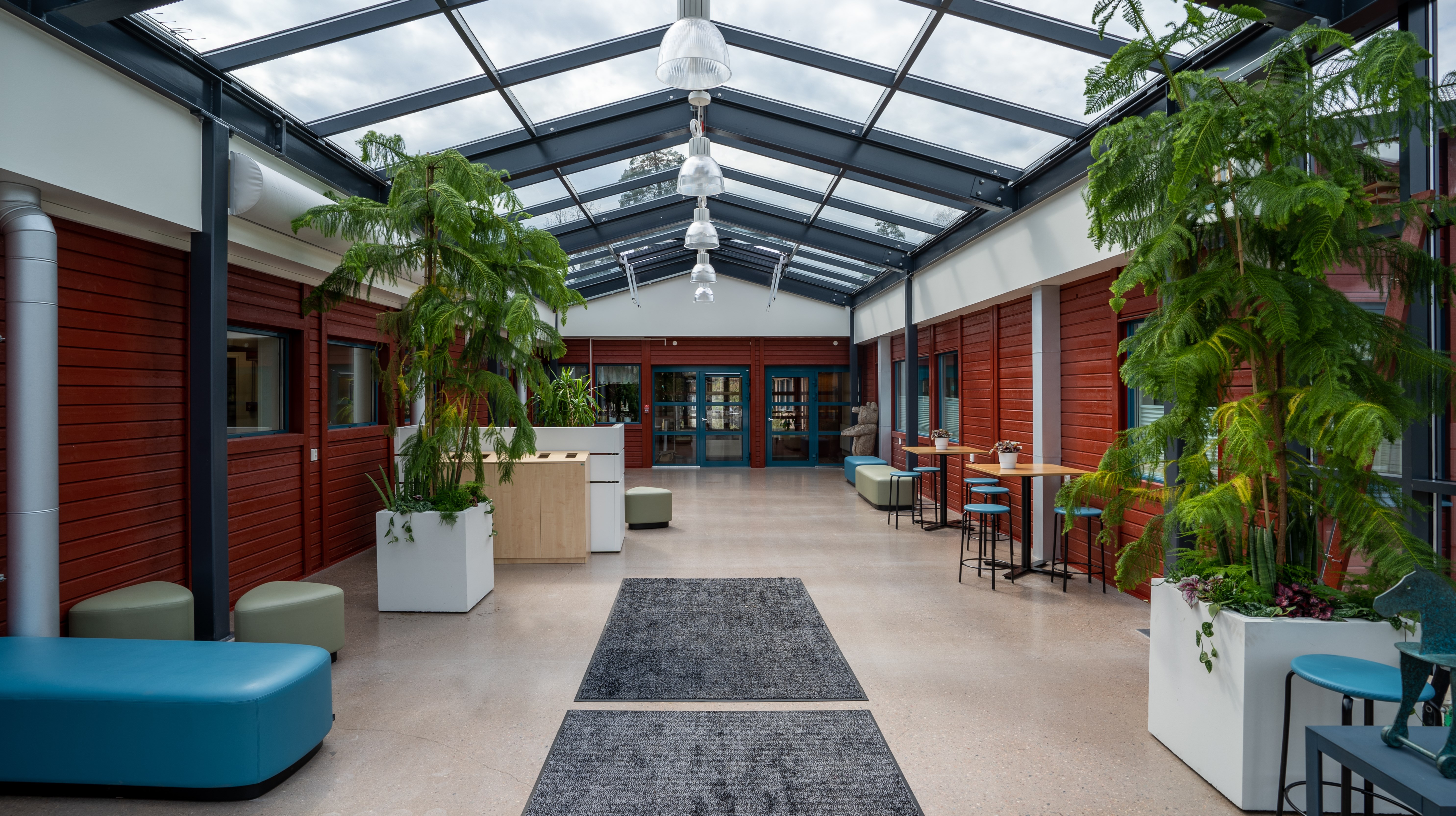 Möblerad entré med glastak, och gröna växter