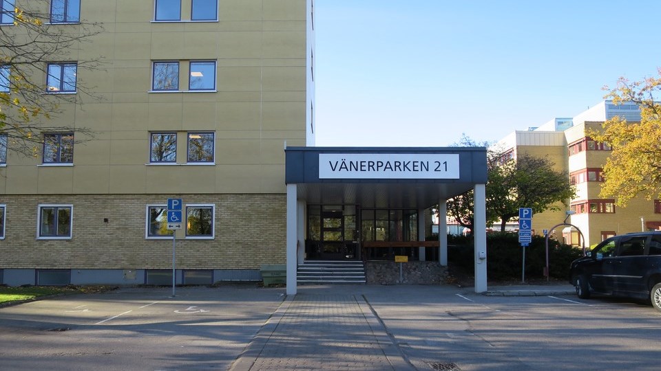 Gul tegelbyggnad med entré där det står Vänerparken 21