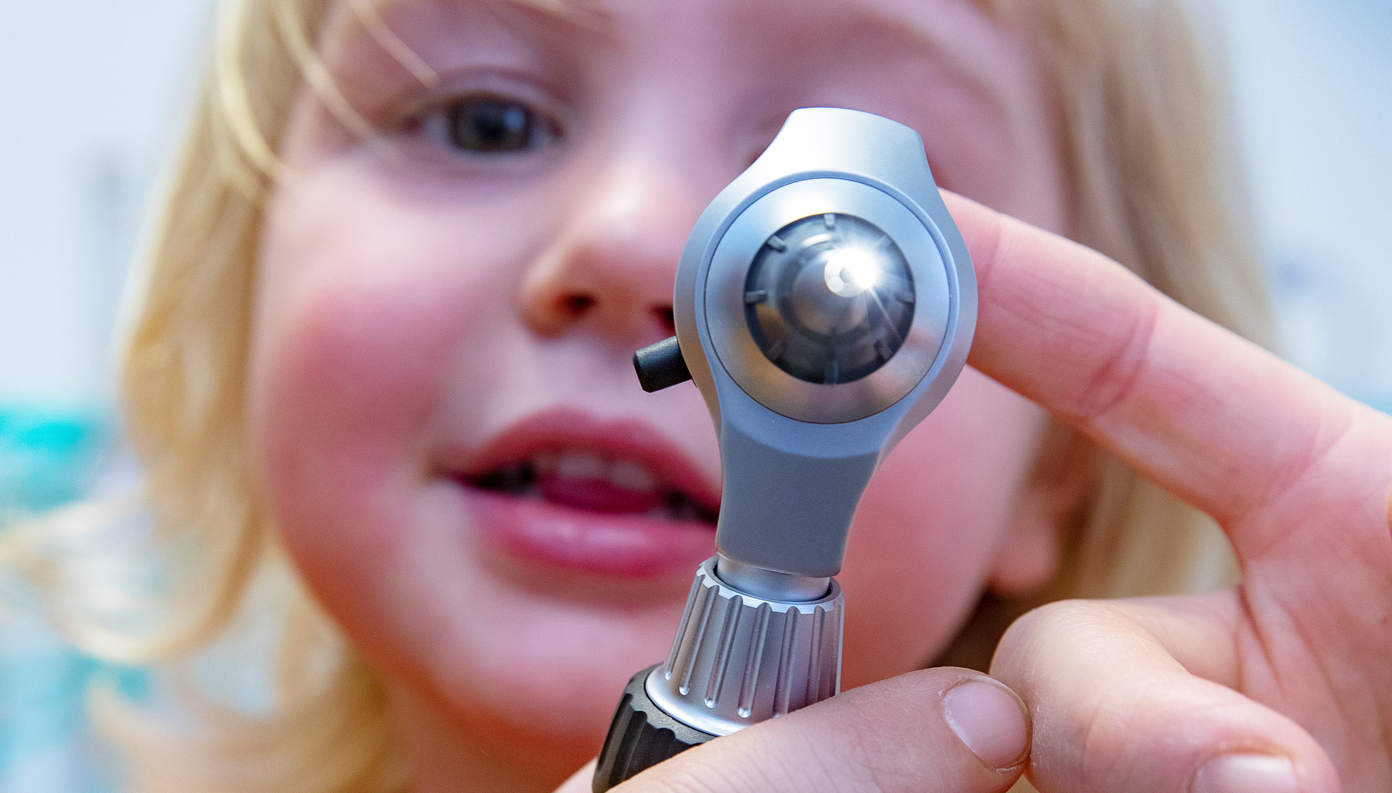 Liten flicka tittar på undersökningsinstrument.