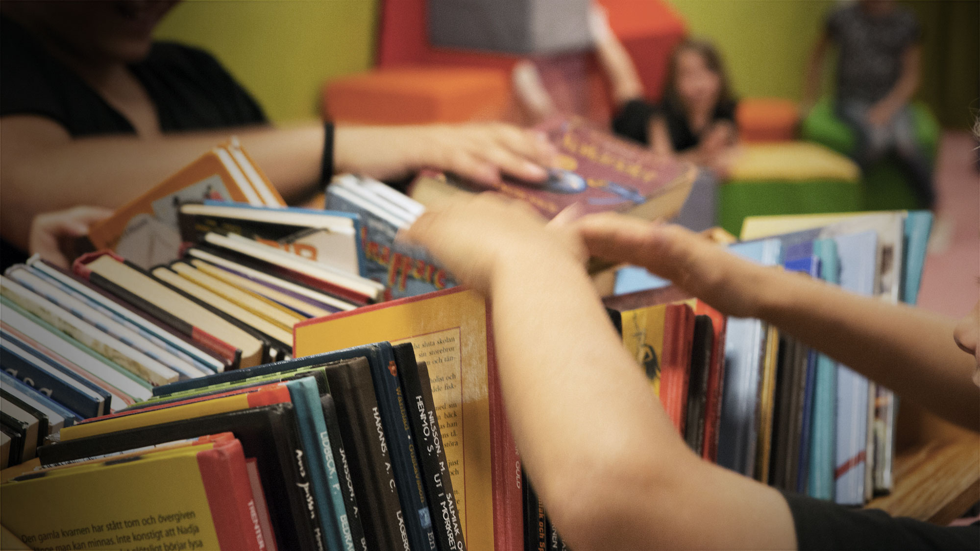 Bild på händer som bläddrar bland böcker