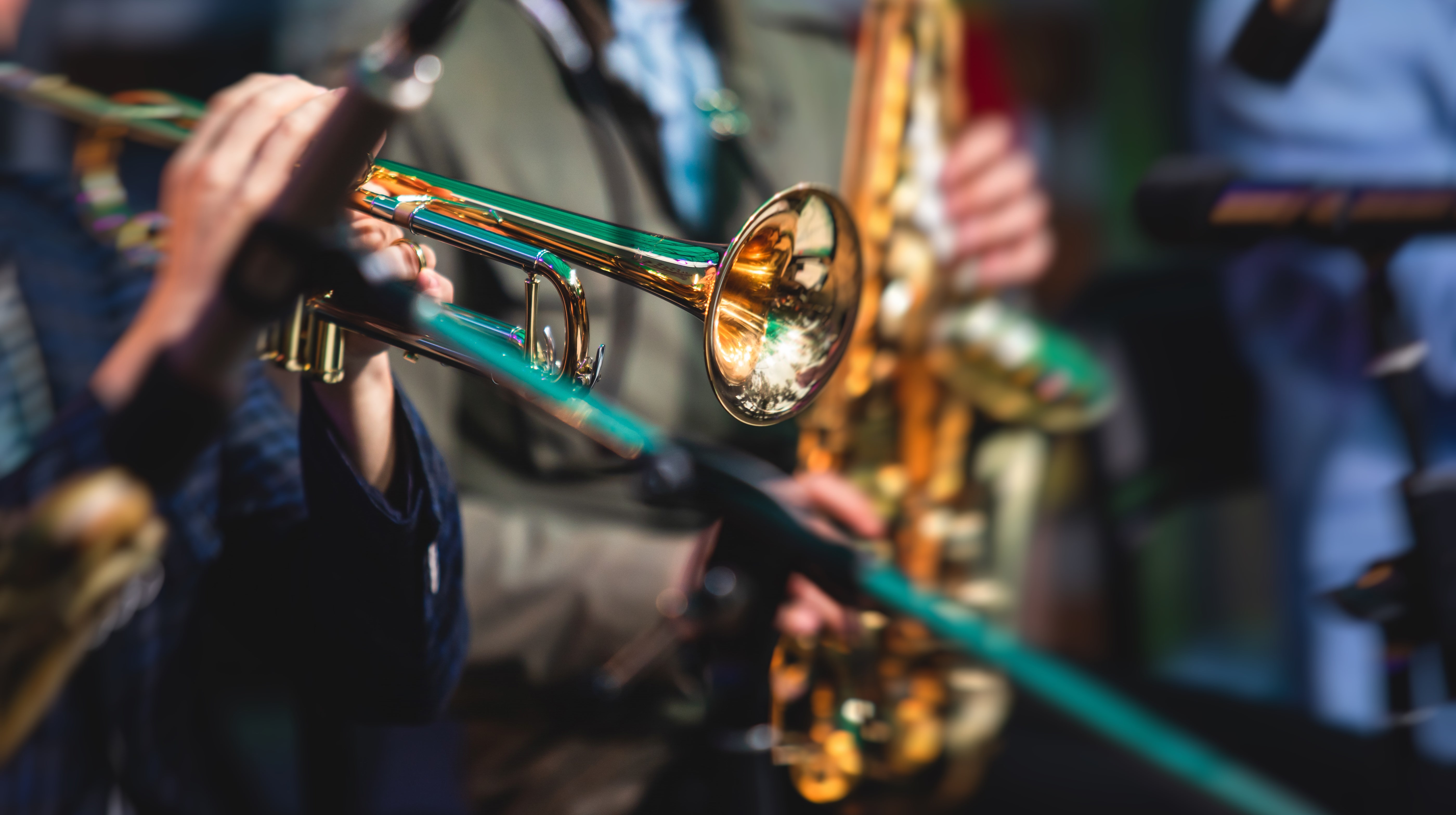 Concert view of a male trumpeter, professional trumpet player with vocalist and musical during jazz band performing
in the background