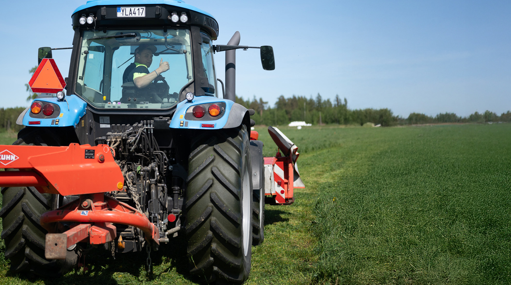 Traktor med slåttermaskin på vall