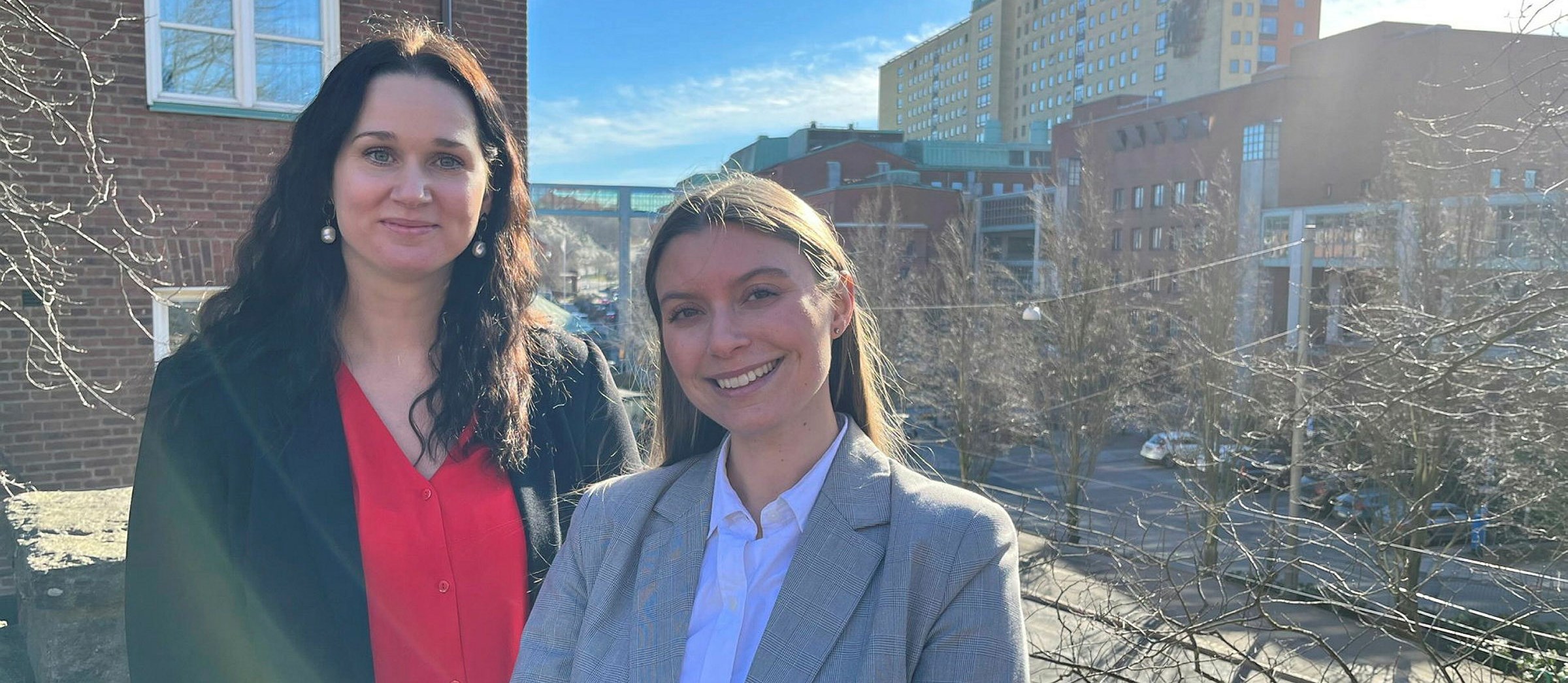 Gothia Forums hälsoekonomer, Emelie Pauli och Stephanie Fledsberg står utomhus. I bakgrunden syns Sahlgrenska Universitetssjukhuset.