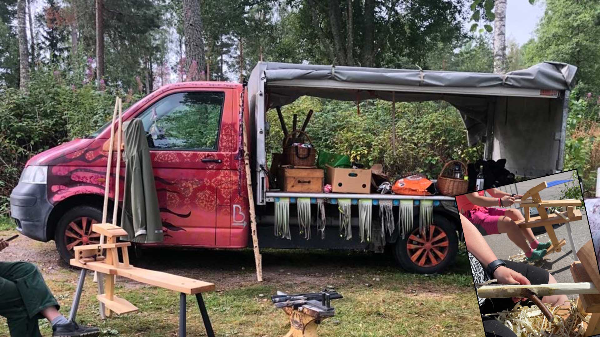 Lastbil som står parkerad i skogen. Rosa förarhytt. Långsidorna är öppna. Man ser kartonger och korgar i lastbilen. En täljbock. I nedre höger hörn är en annan bild infälld. I den ser man händer som täljer i täljbockar. 