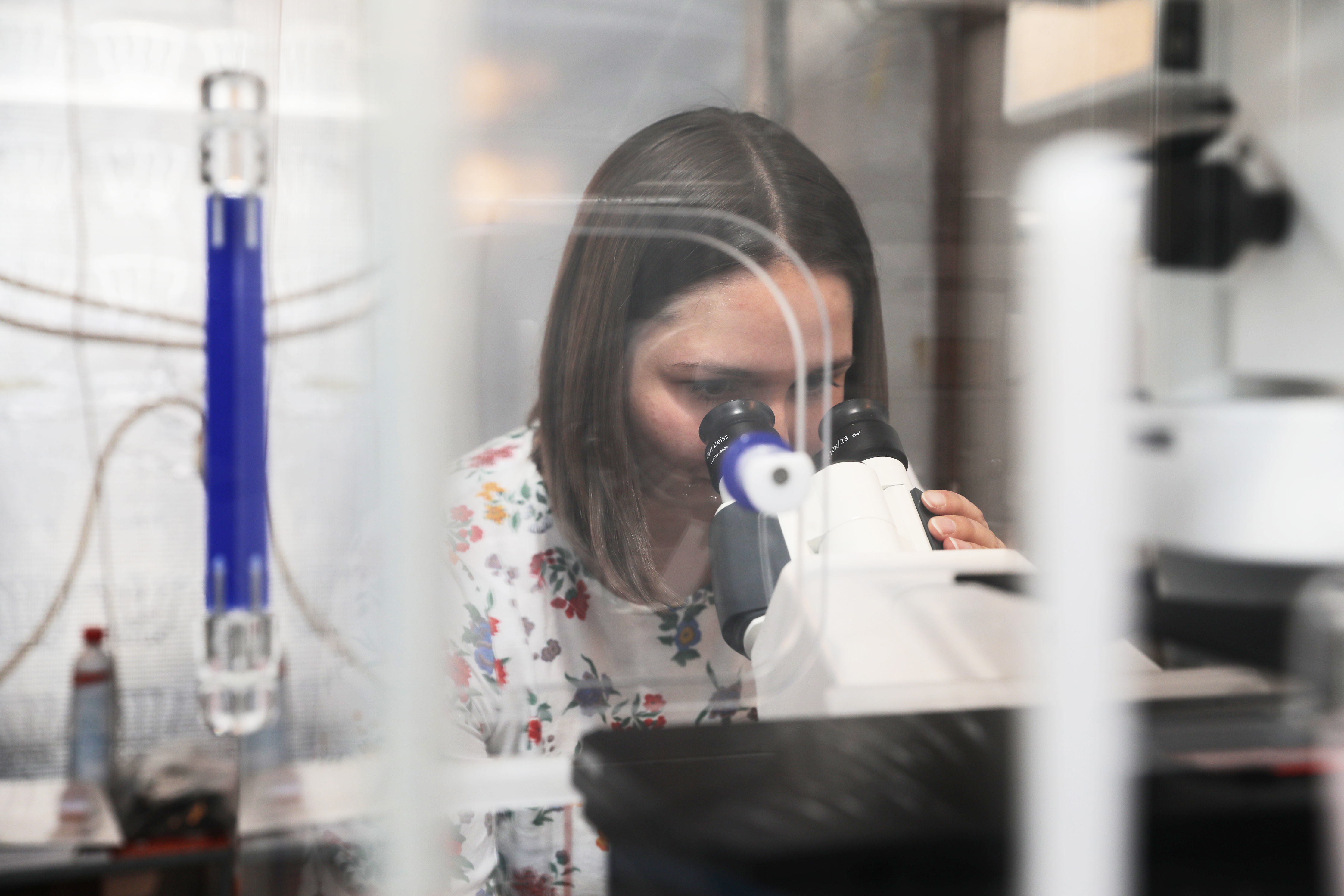 Kvinnlig forskare använder ett mikroskop.