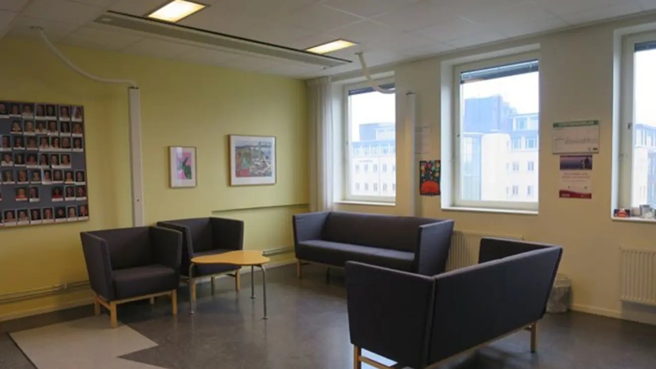 Blå soffor och fåtöljer i grönt väntrum